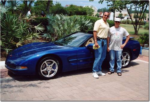 016.Dr. Oscar and Kerry pose beside the Blue Bomber.JPG